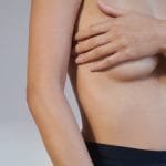 close up of model's midsection after bodytite treatment with hands covering her chest
